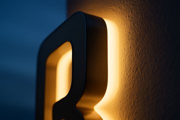 壁から浮かせた立体の面の角。裏から光が漏れて縁取りになっている