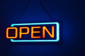 壁に吊るした、OPENの文字のネオン